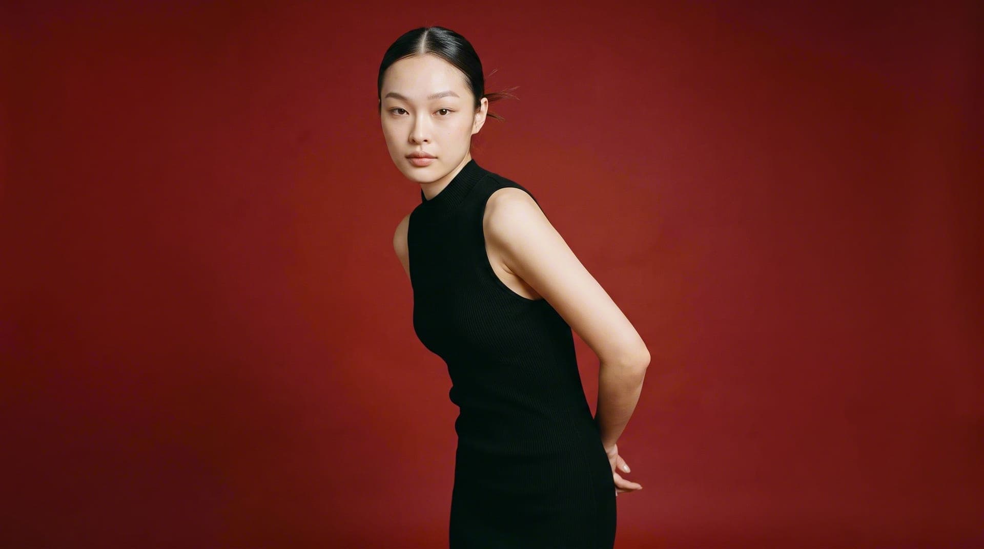 Model for a fashion campaign shot on a deep-red set